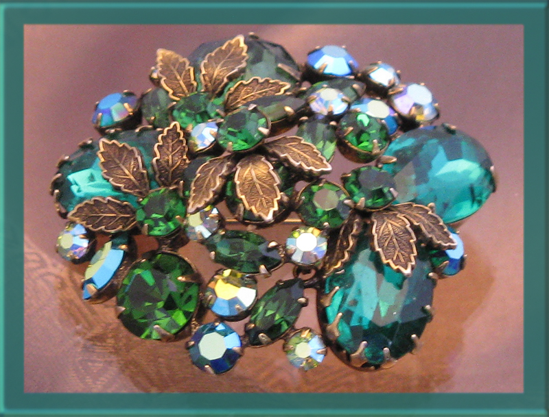 Glorious green brooch with large oval rhinestones and metal leaf accents.